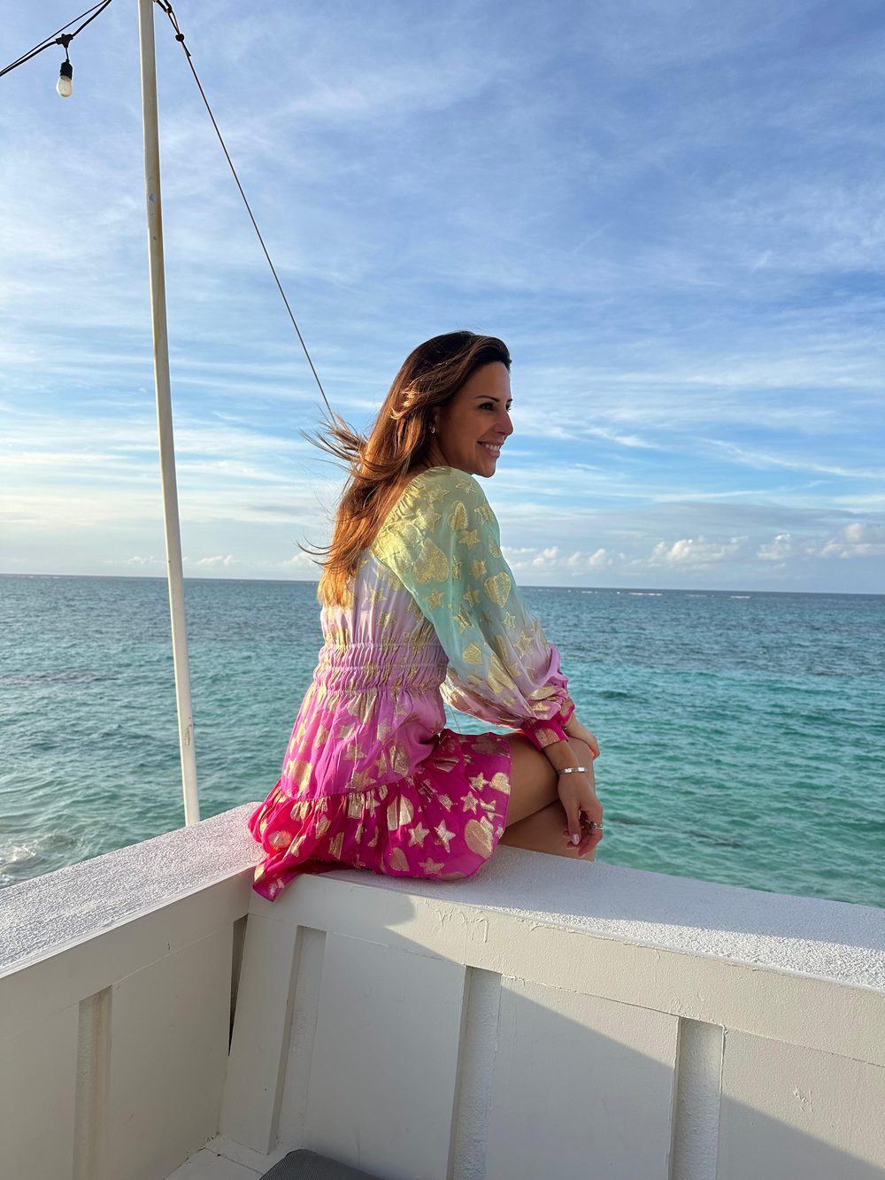 Léa Bidani, the founder of Maison Longevity, sitting above a turquoise sea.
