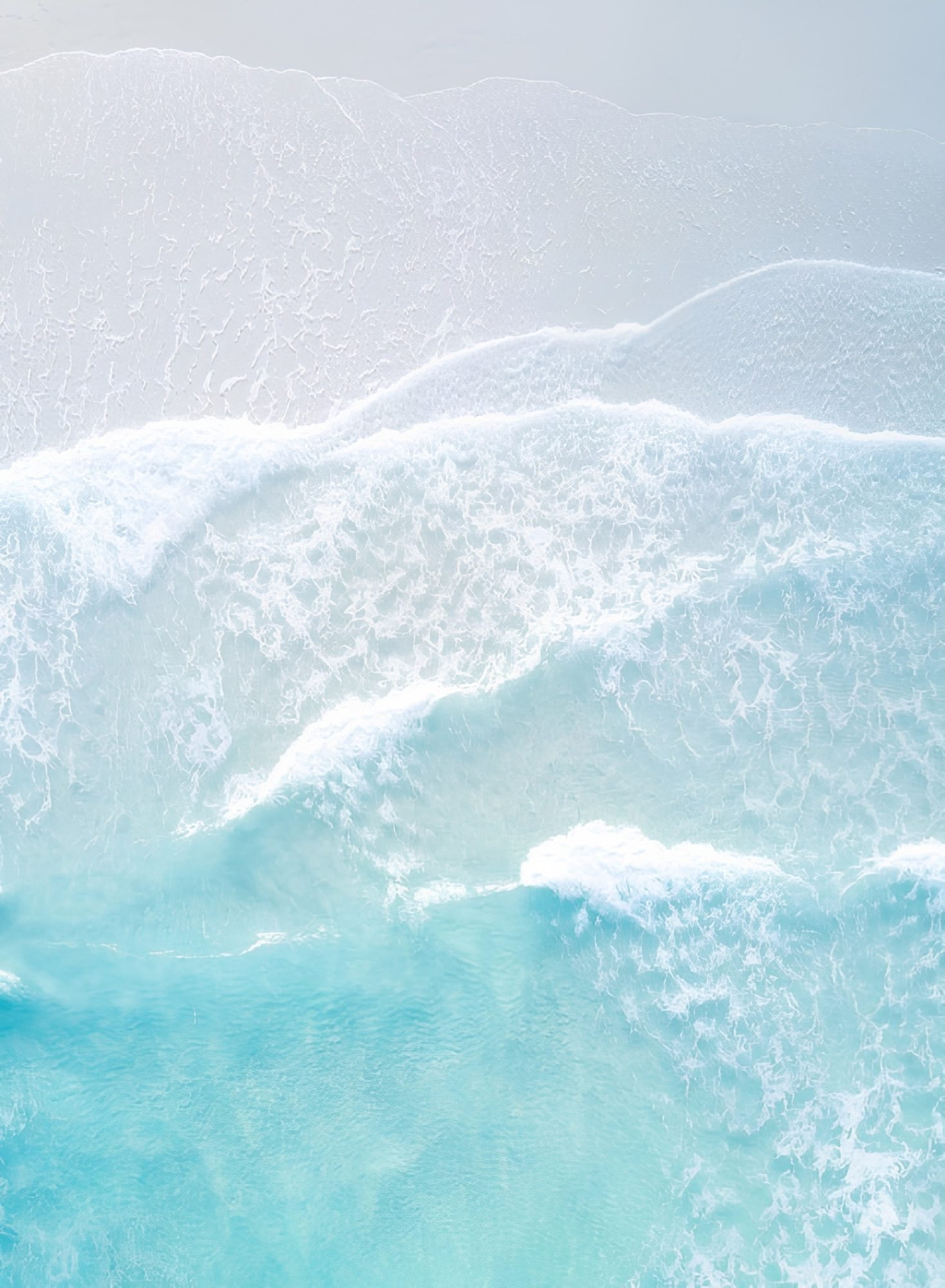 The sea from above, the surf breaking in pale bands.