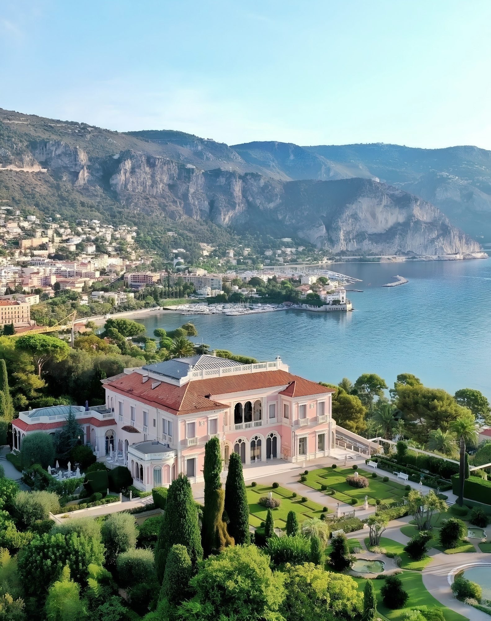A Belle Époque villa and its formal gardens above the bay, the cliffs beyond.