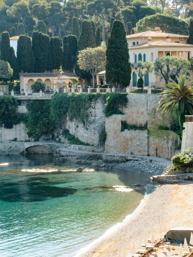 A pebble beach in a sheltered cove, the water turning green over the stones.