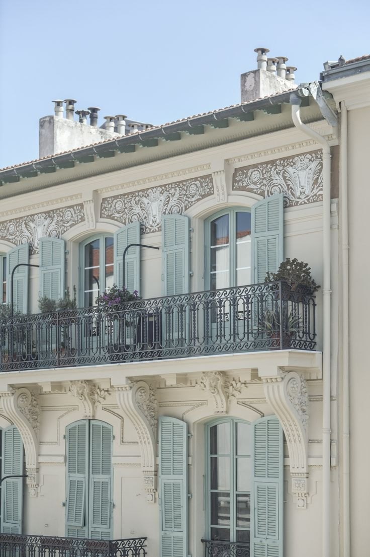 A Belle Époque façade, its shutters in pale blue.