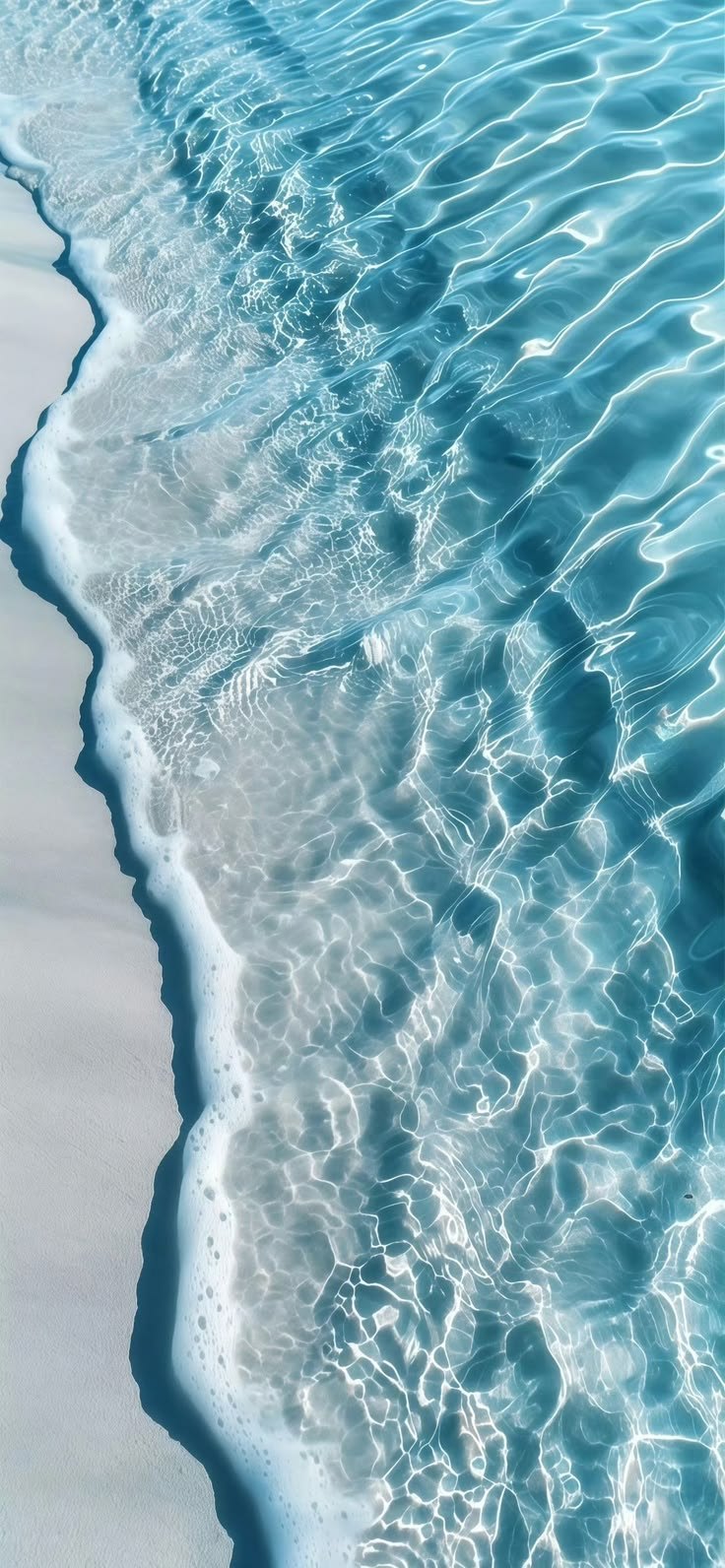 Clear water over pale sand, seen from above.