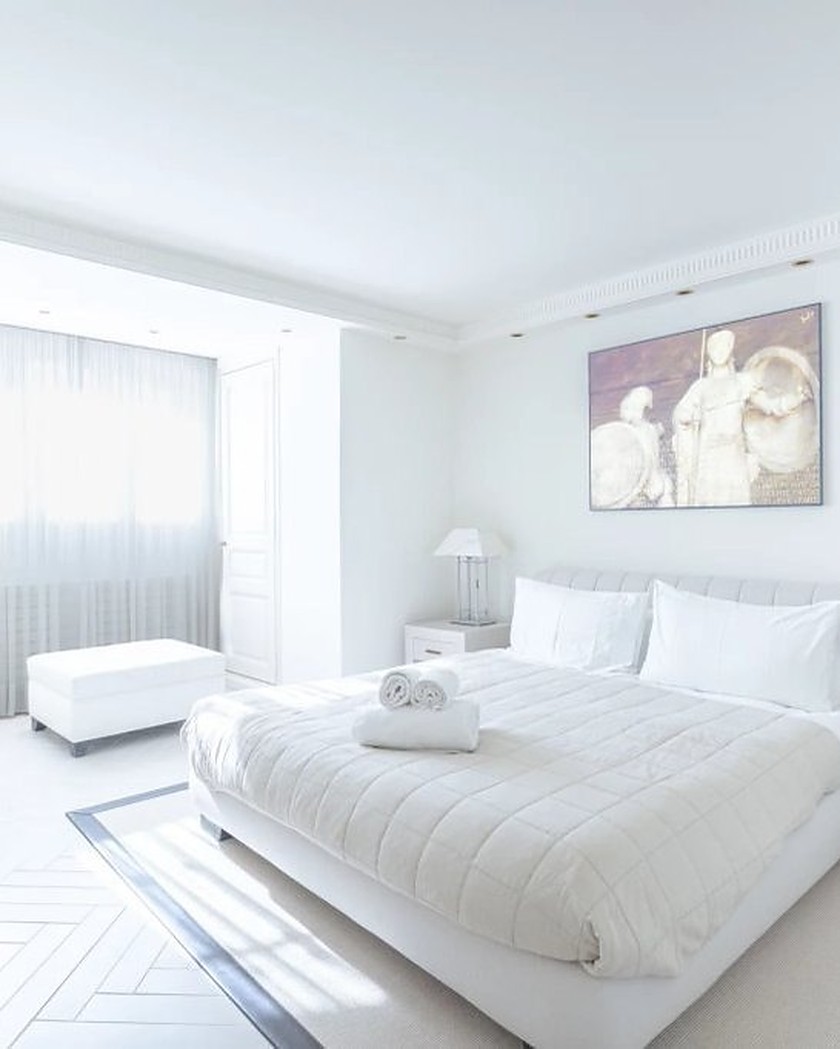 One of the seven bedrooms of the villa, made up in white.