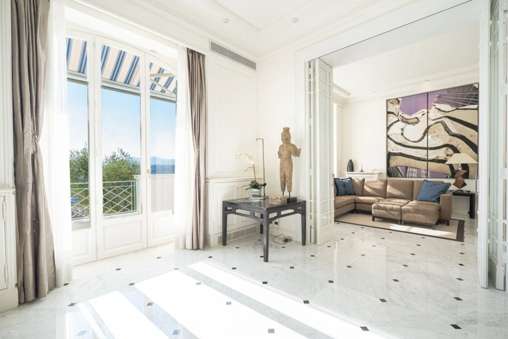 The entrance in white marble, the wrought-iron door and the light beyond.