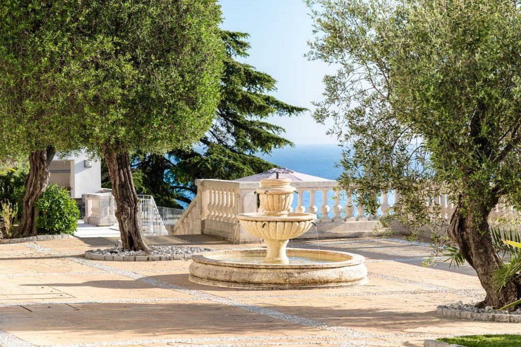 The garden of the villa, its fountain among the olive trees.