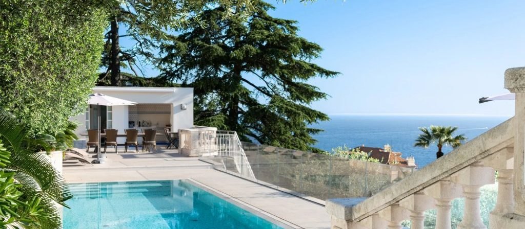 The pool at the edge of the terrace, the Mediterranean beyond the balustrade.